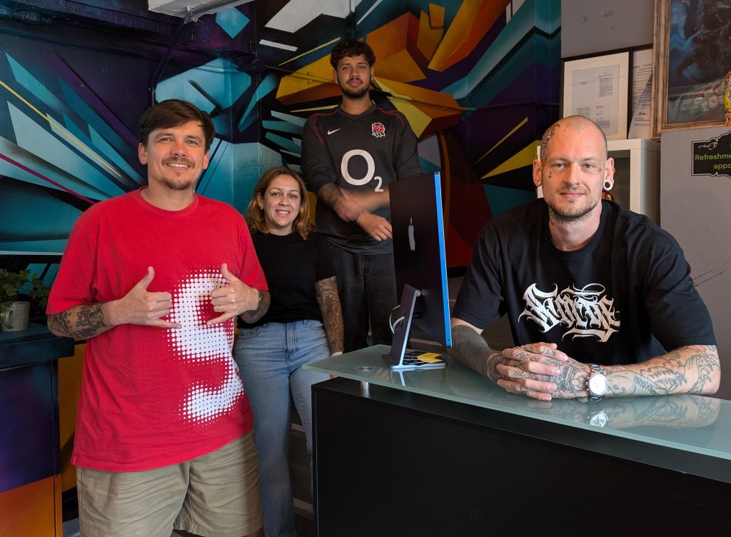 four people around front desk in shop